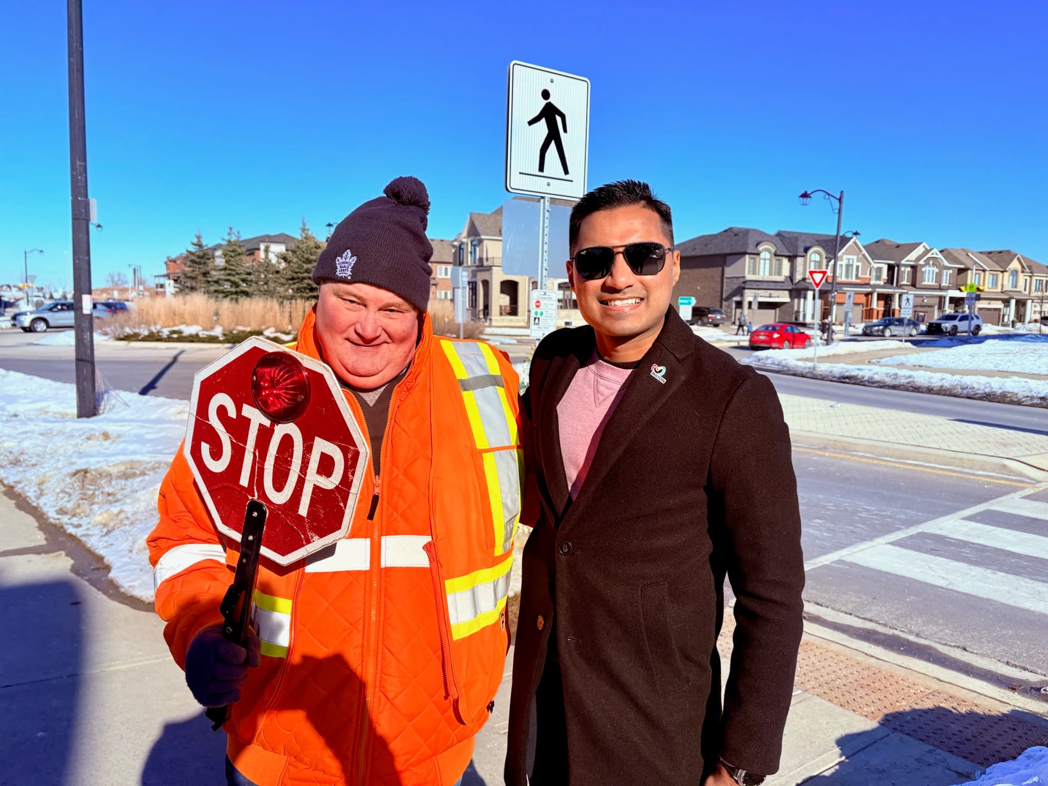 Adil Khalqi with a Milton crossing guard at a school crosswalk